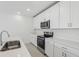 Bright modern kitchen features stainless appliances, quartz countertops, and undermount sink at 312 Castle Dr, Lake Alfred, FL 33850
