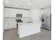 Bright white kitchen features stainless steel appliances and a large kitchen island at 312 Castle Dr, Lake Alfred, FL 33850
