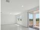 Bright living room with gray tile flooring, large windows, and sliding glass door at 312 Castle Dr, Lake Alfred, FL 33850