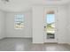 Bright, neutral living room with tile flooring, a large window, and a glass front door at 312 Castle Dr, Lake Alfred, FL 33850