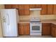 Functional kitchen with white appliances, wooden cabinets, and tile floor at 3734 Hampton Hills Dr, Lakeland, FL 33810