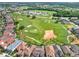 Aerial view of the community with a golf course, sand traps, and gorgeous landscaping at 411 Muirfield Loop, Reunion, FL 34747