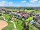 Community aerial showcasing golf course frontage, residential homes, and mature trees at 411 Muirfield Loop, Reunion, FL 34747