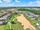 Wide aerial shot showing a community with golf course, lake, and scenic landscape views at 411 Muirfield Loop, Reunion, FL 34747