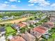 Drone shot of a residential area near a lush golf course, serene ponds, and mature trees at 411 Muirfield Loop, Reunion, FL 34747