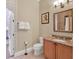 A cozy bathroom featuring a granite countertop, decorative mirror, and elegant fixtures at 411 Muirfield Loop, Reunion, FL 34747