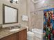 A vibrant bathroom with a granite vanity, neutral tile and Marvel themed shower curtain at 411 Muirfield Loop, Reunion, FL 34747