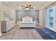 Bright bedroom with white furniture, wood flooring, and a private outdoor balcony at 411 Muirfield Loop, Reunion, FL 34747