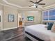 This bedroom offers a view of the ensuite bathroom and features wood floors and a coastal theme at 411 Muirfield Loop, Reunion, FL 34747