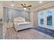 Bright bedroom with white furniture, wood flooring, and a private outdoor balcony at 411 Muirfield Loop, Reunion, FL 34747