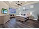 A spacious bedroom features a tray ceiling, wood floors, and a serene color scheme at 411 Muirfield Loop, Reunion, FL 34747