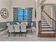 Dining room featuring a modern chandelier, stylish curtains, and an adjacent staircase with wooden railing at 411 Muirfield Loop, Reunion, FL 34747