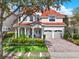 Charming two-story home featuring a red tile roof, arched entryway, two-car garage and beautifully landscaped front yard at 411 Muirfield Loop, Reunion, FL 34747