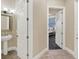 The hallway leads to a bedroom with a serene color palette and an adjacent powder room at 411 Muirfield Loop, Reunion, FL 34747