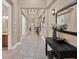 A grand home hallway boasting designer tile flooring, decorative mirror, and a view of the staircase at 411 Muirfield Loop, Reunion, FL 34747