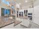 A modern kitchen featuring granite counters, stainless appliances, a center island, and an elegant chandelier at 411 Muirfield Loop, Reunion, FL 34747