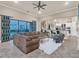 Open-concept living area with a large sectional sofa, stylish decor, and access to the kitchen at 411 Muirfield Loop, Reunion, FL 34747