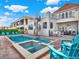 Backyard view with a pool, hot tub, bar, outdoor furniture, patio and a spiral staircase to the rooftop deck at 411 Muirfield Loop, Reunion, FL 34747