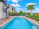 Private swimming pool featuring a sun deck, palm trees, and a spiral staircase that goes to the home's balcony at 411 Muirfield Loop, Reunion, FL 34747