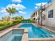 A luxurious swimming pool and spa featuring brick pavers and a spiral staircase that goes to the home's balcony at 411 Muirfield Loop, Reunion, FL 34747