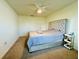 Neutral bedroom featuring a tufted headboard, ceiling fan, carpet, and natural light at 417 Patricia Alford Dr, Haines City, FL 33844