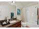 Bathroom featuring a shower-tub combo with white tile, brown vanity, and dark countertop at 432 Treasure Ln, Sanford, FL 32771