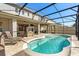 Sparkling pool inside screened lanai with chairs, fireplace and outdoor seating at 432 Treasure Ln, Sanford, FL 32771