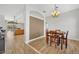 Dining area featuring wood-look tile flooring and stylish chandelier, adjacent to open kitchen at 4907 Culdesac Ct, St Cloud, FL 34772