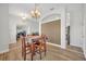 Bright dining room open to the home office space with wood-look tile flooring and chandelier at 4907 Culdesac Ct, St Cloud, FL 34772