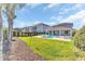 Wide view of the backyard including a pool, spa, lounge seating and well-manicured lawn at 501 Burma St, Kissimmee, FL 34747