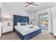 Bright bedroom features a blue bed frame and headboard, ceiling fan, and sliding glass doors to a patio at 501 Burma St, Kissimmee, FL 34747