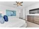 Well-lit bedroom with a large painting, TV, closet, and ensuite bathroom at 501 Burma St, Kissimmee, FL 34747