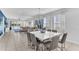 Open concept dining room featuring a sleek white table, stylish gray chairs, and a modern chandelier at 501 Burma St, Kissimmee, FL 34747