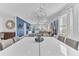 Bright dining room featuring a modern white table, chairs, light fixture and blue accent wall at 501 Burma St, Kissimmee, FL 34747