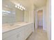 Well-lit bathroom with double vanity sinks, quartz countertops, and tiled walk-in shower at 5074 Sparkling Water Way, Kissimmee, FL 34746