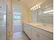 Bright bathroom with a double vanity, walk-in shower, and serene lake view at 5074 Sparkling Water Way, Kissimmee, FL 34746