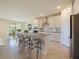 Well-lit kitchen with stainless steel appliances, gray countertops, white cabinets, and island with barstool seating at 5074 Sparkling Water Way, Kissimmee, FL 34746