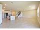 Open-concept living space with tile flooring, leading to a modern kitchen and staircase at 5074 Sparkling Water Way, Kissimmee, FL 34746