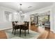 Open concept dining room with hardwood floors, modern lighting, and view into the living room at 520 Oriole Dr, Lakeland, FL 33803