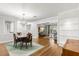 Open concept dining room with hardwood floors, modern lighting, and an opening into the living room at 520 Oriole Dr, Lakeland, FL 33803