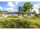 Charming gray brick home featuring a bright yellow front door and manicured front lawn at 520 Oriole Dr, Lakeland, FL 33803