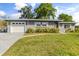 Exterior view of a charming gray brick home featuring an attached garage and well-maintained lawn at 520 Oriole Dr, Lakeland, FL 33803