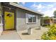 Close up of front porch with a bright yellow door and concrete sitting area with plants at 520 Oriole Dr, Lakeland, FL 33803