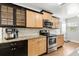 Kitchen with stainless steel appliances, granite countertops, light wood cabinets, and dark lower cabinets at 520 Oriole Dr, Lakeland, FL 33803