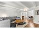 Bright living room with wood floors, beamed ceilings, a gray sectional sofa, and a round coffee table at 520 Oriole Dr, Lakeland, FL 33803