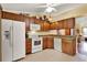 Bright kitchen featuring wooden cabinetry, white appliances, and tile flooring at 5429 Lake Margaret Dr # 185, Orlando, FL 32812