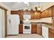 Bright kitchen featuring wooden cabinetry, white appliances, and tile flooring at 5429 Lake Margaret Dr # 185, Orlando, FL 32812