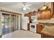 Bright kitchen featuring wooden cabinetry, white appliances, and sliding glass door to patio at 5429 Lake Margaret Dr # 185, Orlando, FL 32812