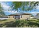 Home's rear view featuring a well-maintained lawn, screened lanai, and solar panels at 5832 Tarleton Way, Mount Dora, FL 32757