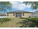 Home's rear view featuring a well-maintained lawn, screened lanai, and solar panels at 5832 Tarleton Way, Mount Dora, FL 32757